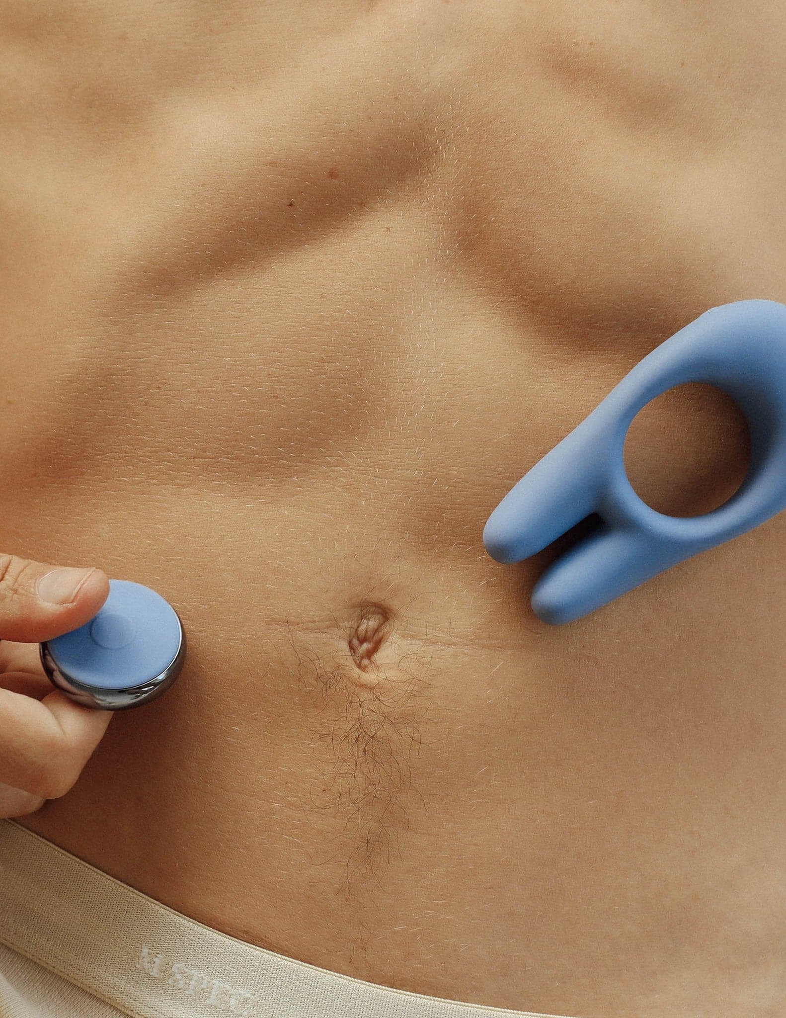 Male Model holding the remote control silicone penis ring with two prong rabbit ears 