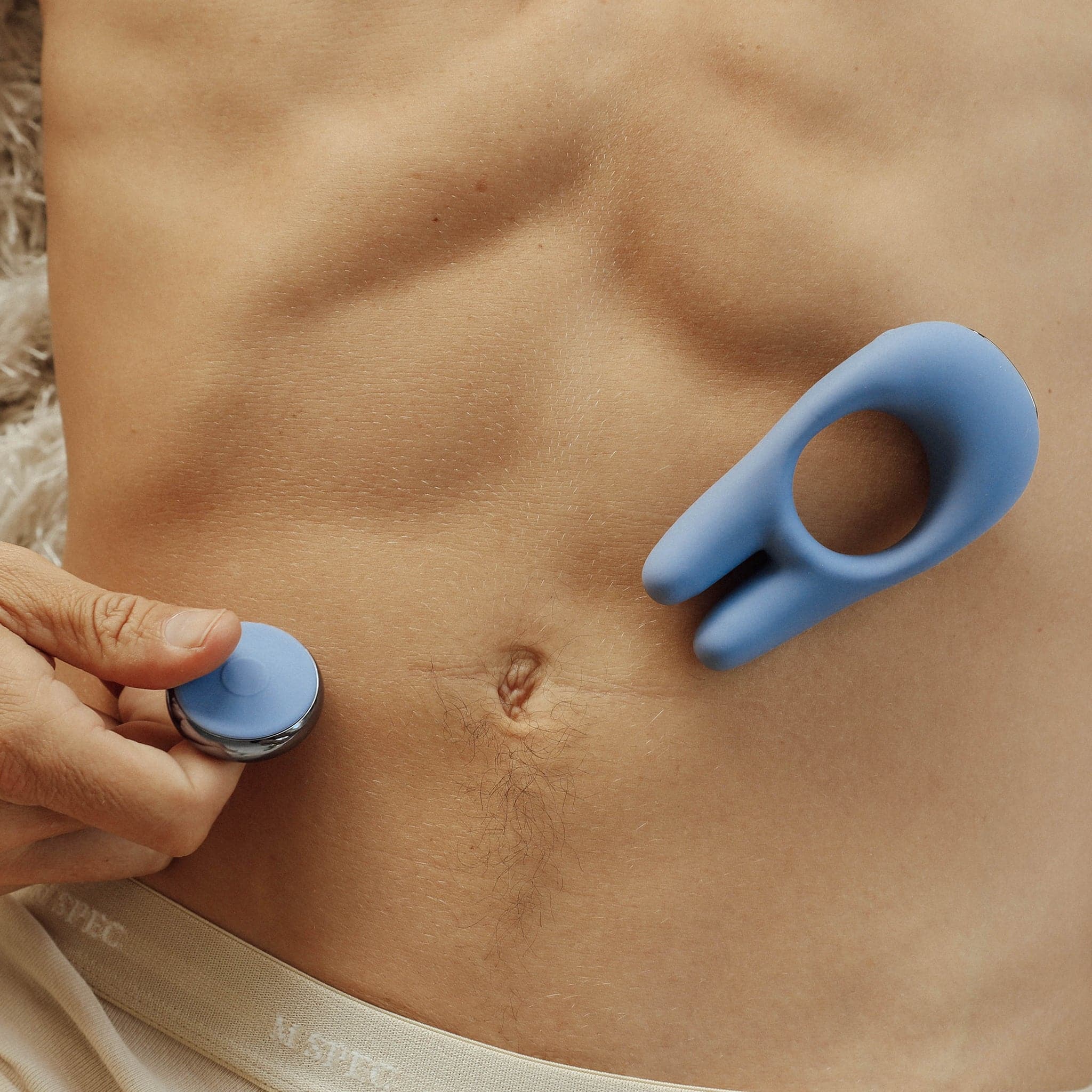 Male Model holding the remote control silicone penis ring with two prong rabbit ears 